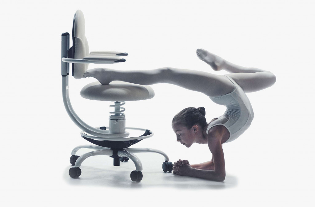 Deklica telovadi na belem pisarniškem stolu